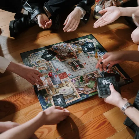 Adults sitting on the floor playing a board game