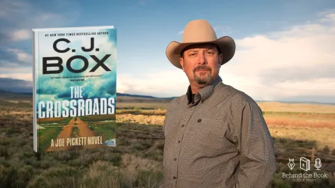A portrait of author CJ Box wearing a cowboy hat standing in front of the rolling hills of Wyoming. To his left is the cover of his upcoming book "The Crossroads"