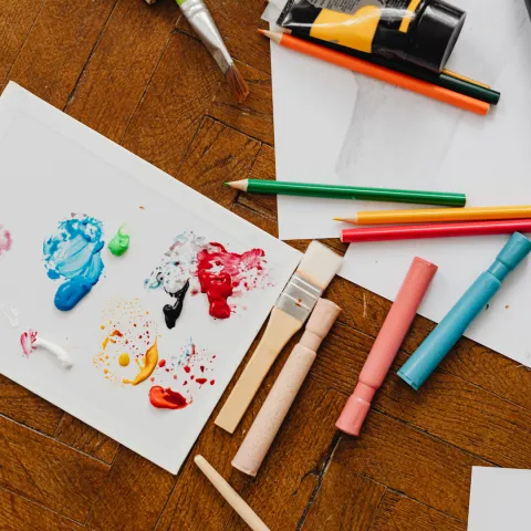 Paint placed on an envelope and art tools for creating mail art