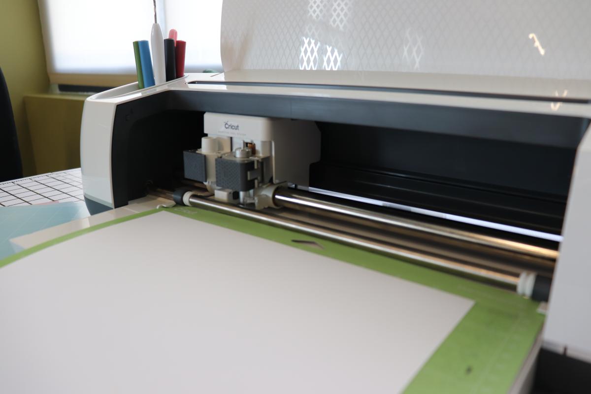 A Cricut maker 3 with paper loaded to be cut