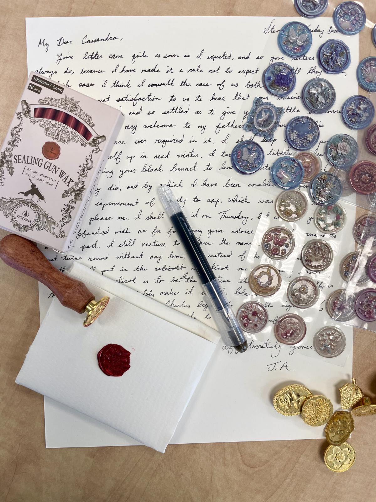 Letter writing materials and wax seal materials displayed on a desk.