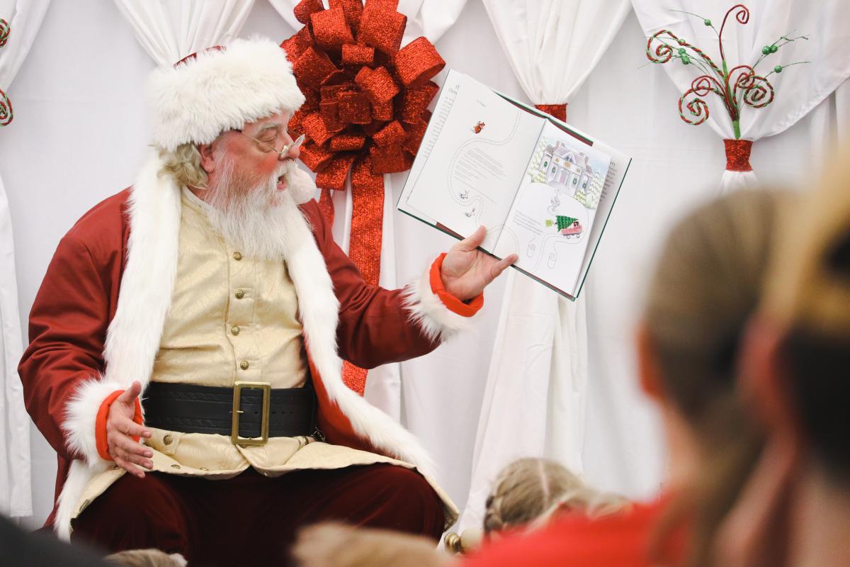 Santa Claus wearing reading a picture book 